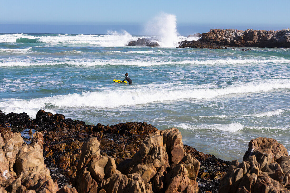 Südafrika, Hermanus, Junge (10-11) auf dem Surfbrett am Kammabaai Beach