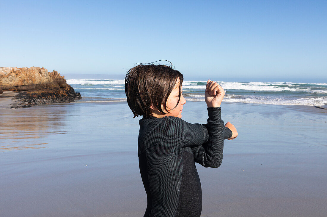 Boy (10-11) stretching on Kammabaai Beach