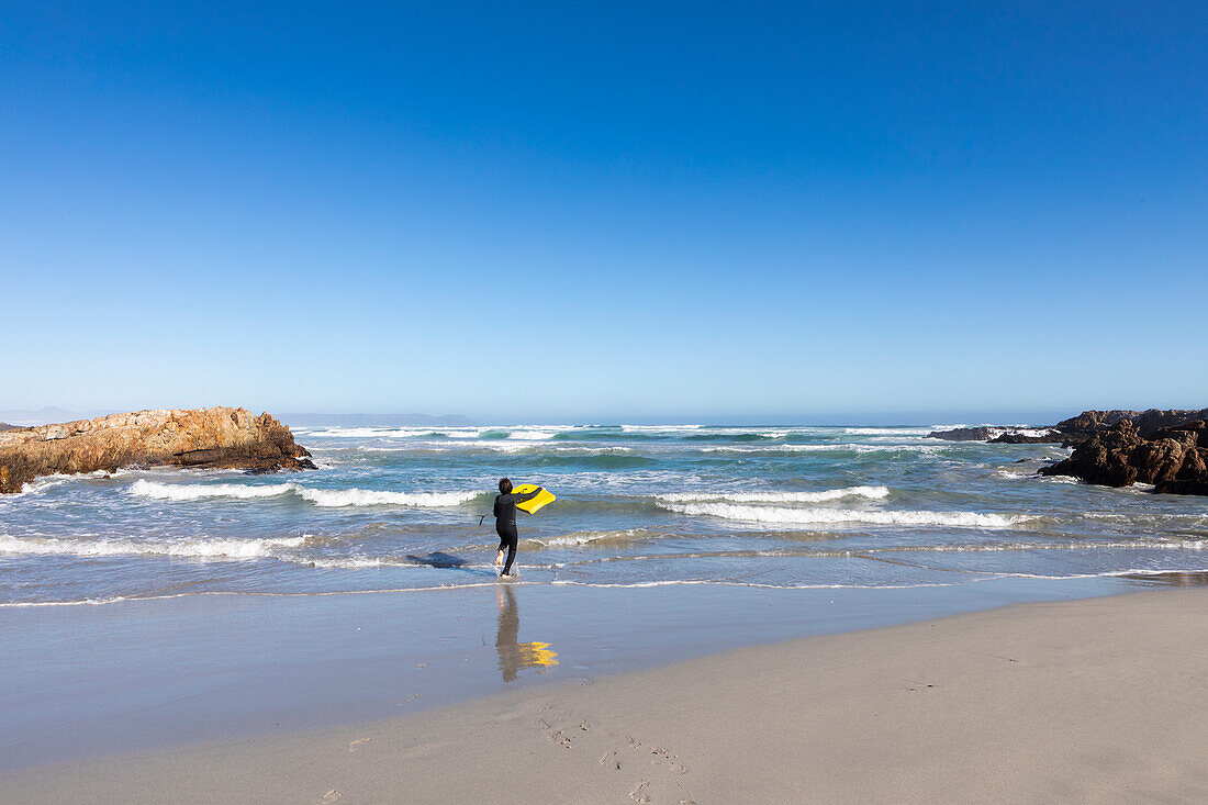 Junge (10-11) beim Surfen am Kammabaai-Strand