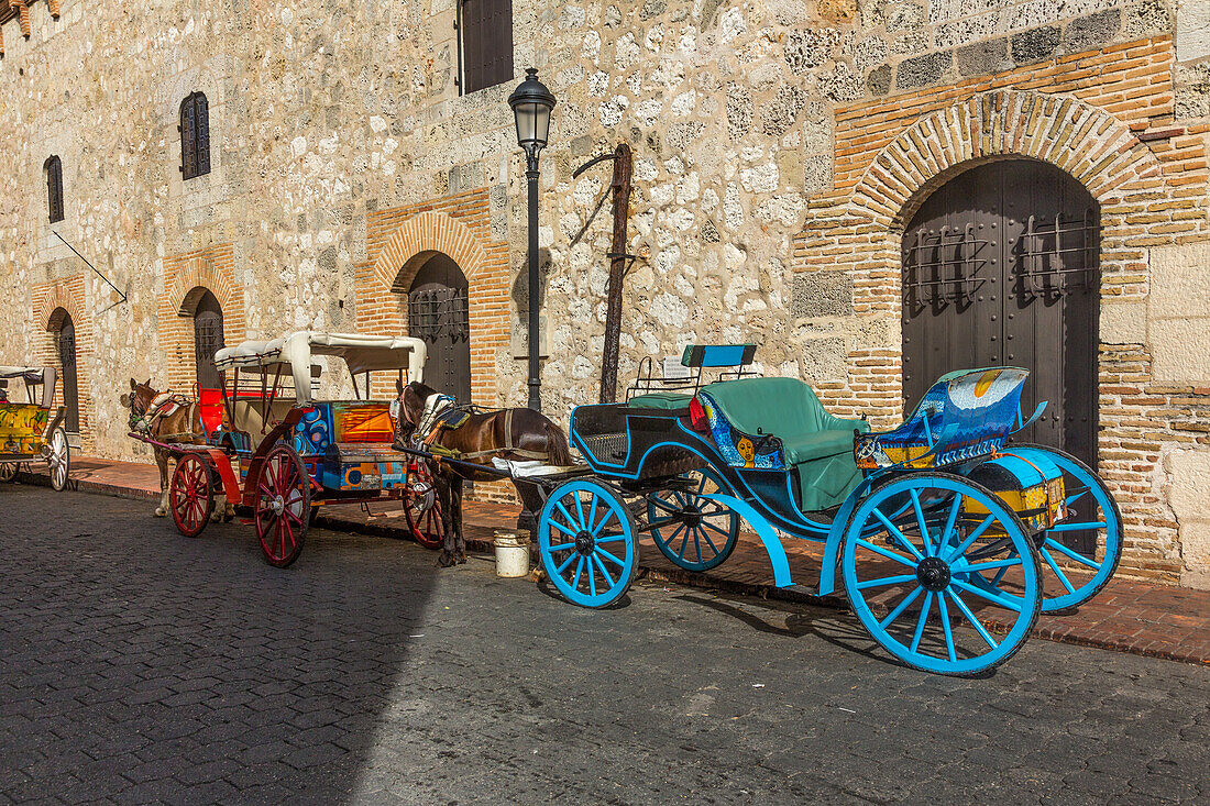 Bemalte Pferdekutschen warten auf Fahrgäste in der alten Kolonialstadt Santo Domingo, Dominikanische Republik. UNESCO-Weltkulturerbe der Kolonialstadt Santo Domingo.