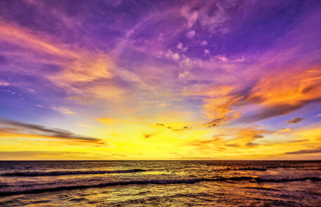 Das goldene Licht der untergehenden Sonne reflektiert einen goldenen Schimmer auf dem Strand von Pererenan Beach, Bali, Indonesien