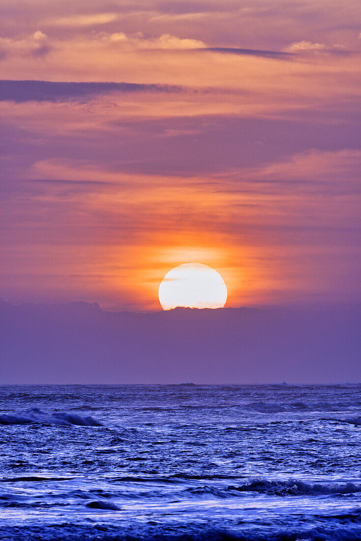 Nächtliches Ritual, bei dem sich Touristen versammeln, um den fantastischen Sonnenuntergang über dem Indischen Ozean am Pererenan Beach zu beobachten, Bali, Indonesien