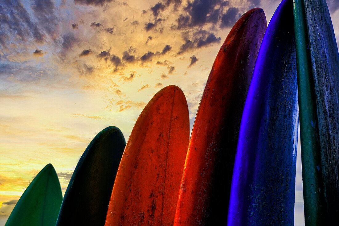 Gestapelte Surfbretter bei Sonnenuntergang nach einem Tag in der Surfschule in Canggu, Bali, Indonesien