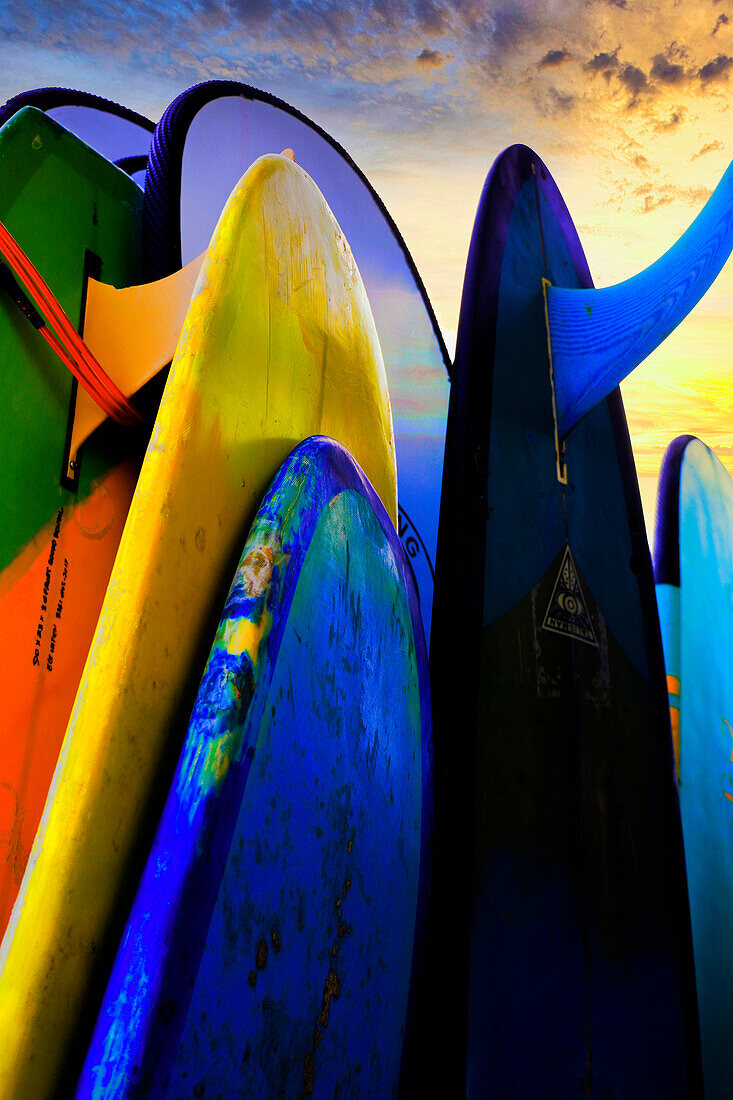 Stacked surf boards at sunset after a day of surf school in Canggu, Bali, Indonesia