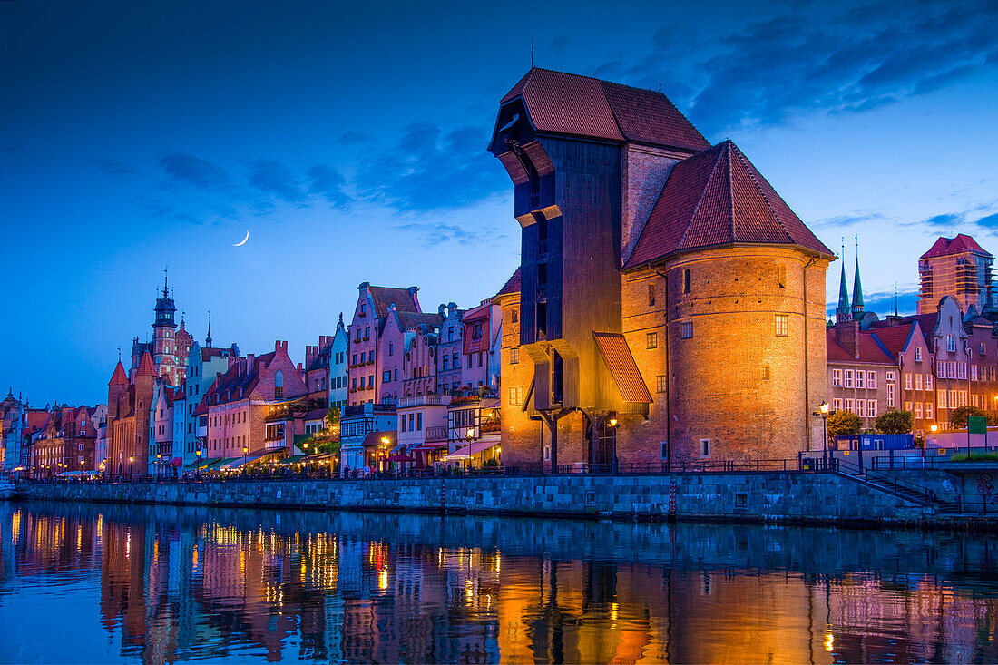 Europa, Polen, Danzig. Mondkomposit und sich im Fluss spiegelnde Stadtgebäude bei Sonnenuntergang.