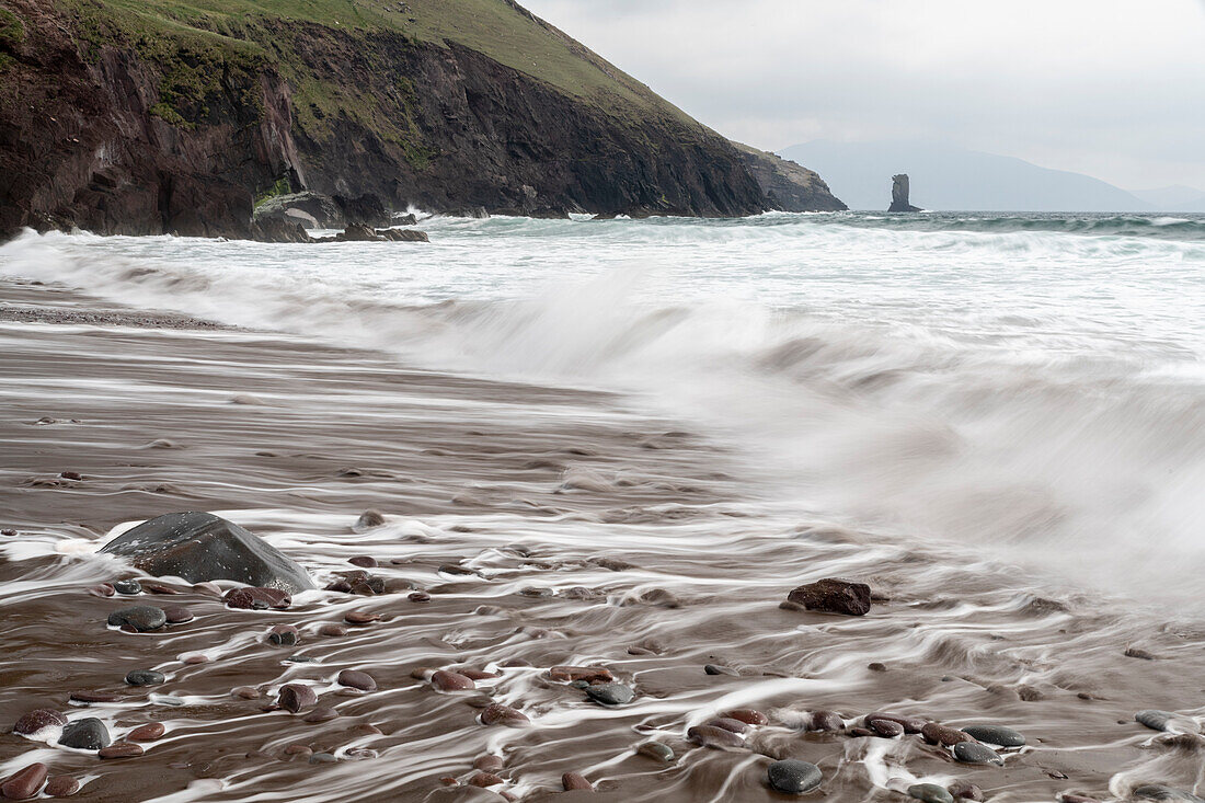 Ireland, County Kerry, Dunmore Head. Cliff and wave on ocean and beach.