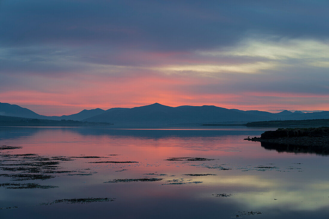 Ireland, Portmagee Bay. Landscape of sunrise on ocean and mountains.