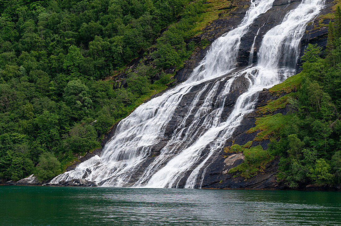 Die Wasserfälle von Seven Sisters stürzen von steilen Klippen in den Geirangerfjord, Norwegen.