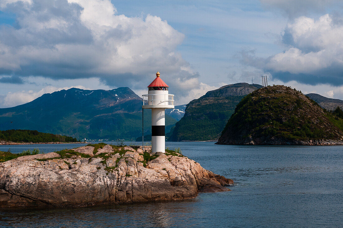 A small lighthouse perched on a rock promontory in Hollandsfjord, Svartisen, Norway.