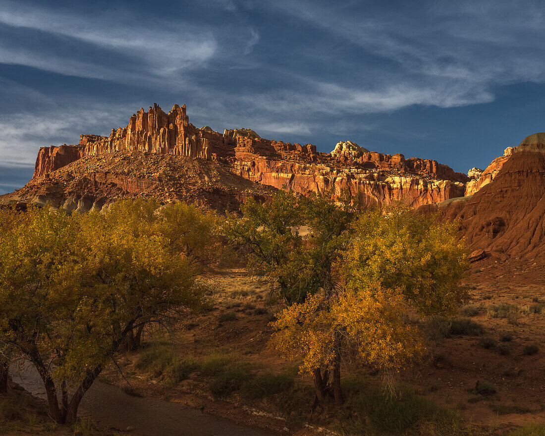 USA, Utah, Capital Reef National Park. Sunrise on mountain formations and trees.