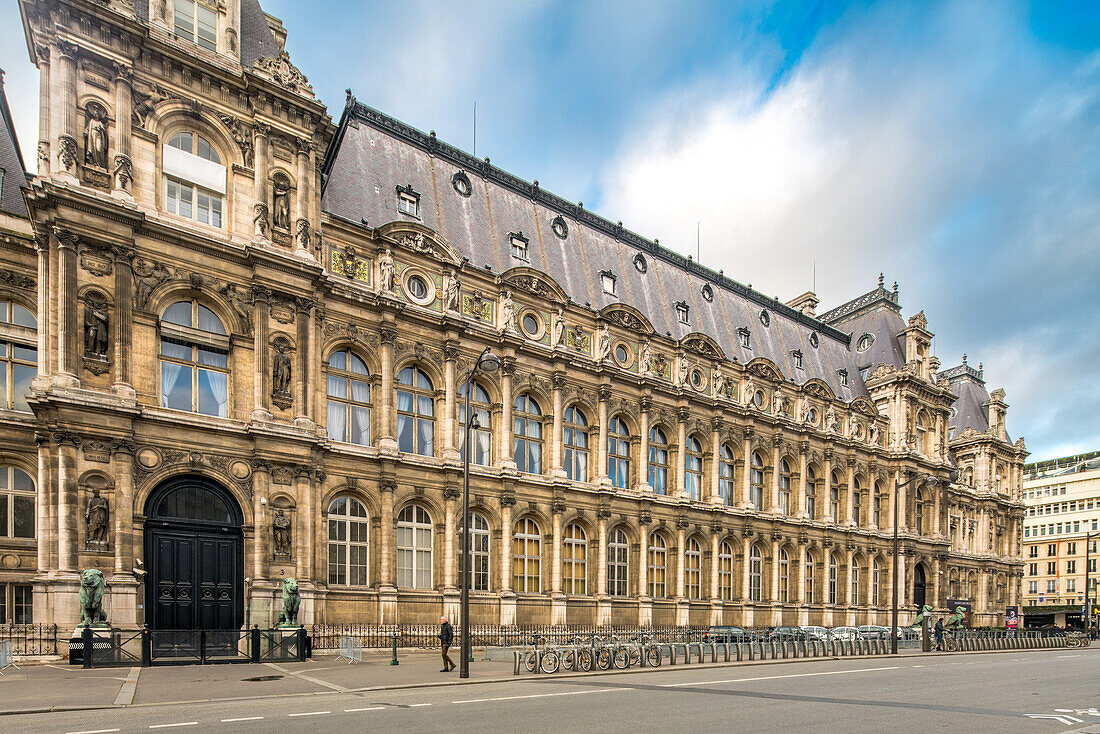 Die verschnörkelte Rückfassade des Pariser Hotel de Ville steht unter einem bewölkten Himmel.