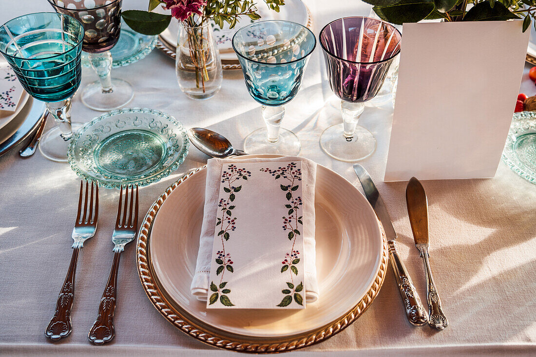 Hohe Winkel der serviert festlichen Tisch mit Kristallgläsern Besteck Serviette auf dem Teller in der Nähe Strauß frischer Blumen für die Hochzeit und Menükarte