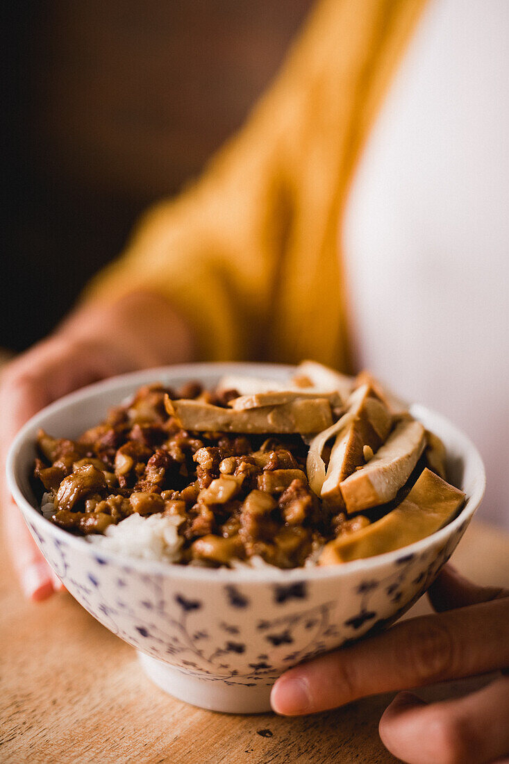 Keramikschüssel mit leckerem Lu Rou Fan-Gericht mit Tofu auf einem Tisch in einem Cafe