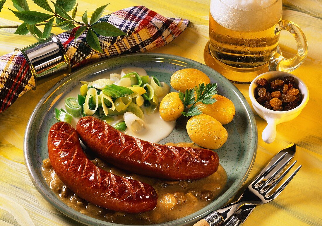 Polish sausages on raisin sauce with potatoes and leeks