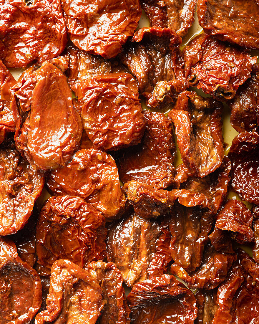 Draufsicht auf appetitliche, saftige, sonnengetrocknete Tomaten, die auf einem Tisch als abstrakter Hintergrund angeordnet sind