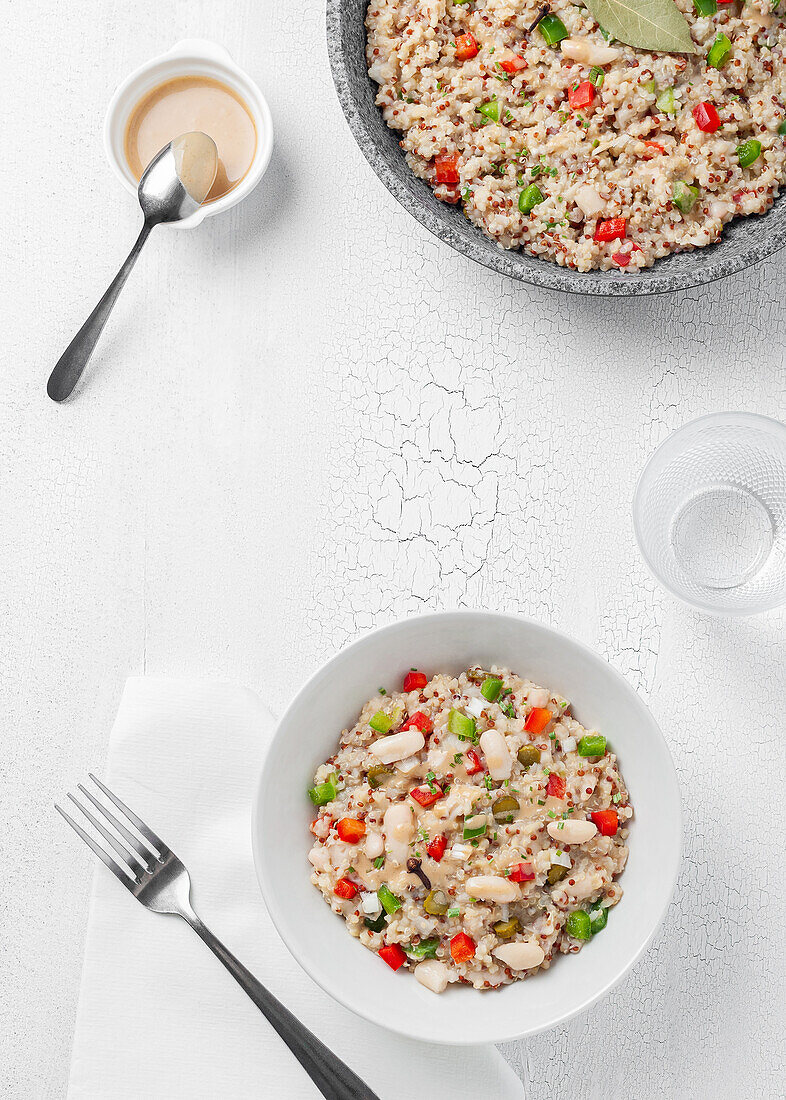 Nahaufnahme von mehreren Tellern mit Bulgur-Quinoa-Bohnen auf einem weißen Tisch