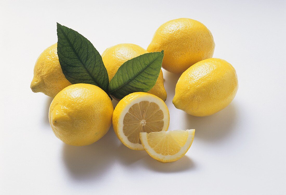 A few lemons with two leaves, lemon half and slice