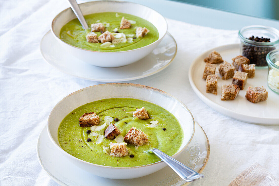 Von oben: leckere Zucchinicremesuppe mit Croutons in Schalen auf dem Tisch zu Hause