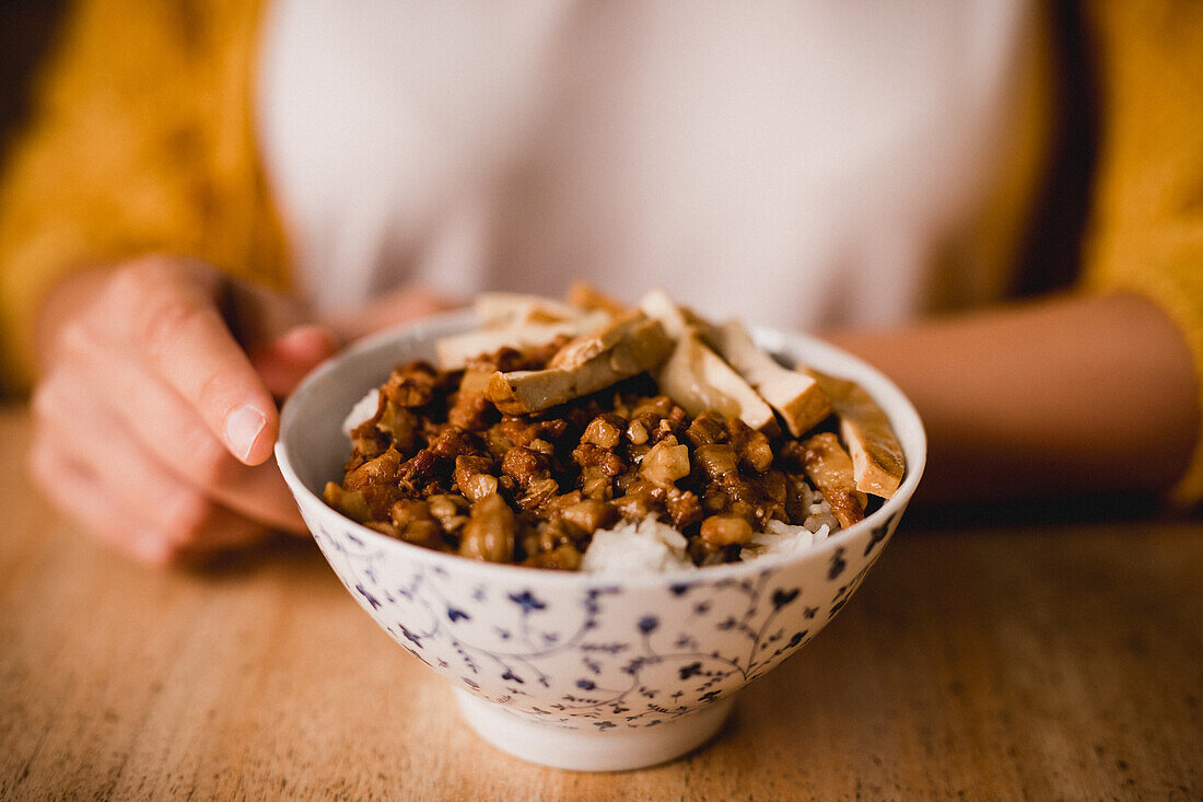 Keramikschüssel mit leckerem Lu Rou Fan-Gericht mit Tofu auf einem Tisch in einem Cafe