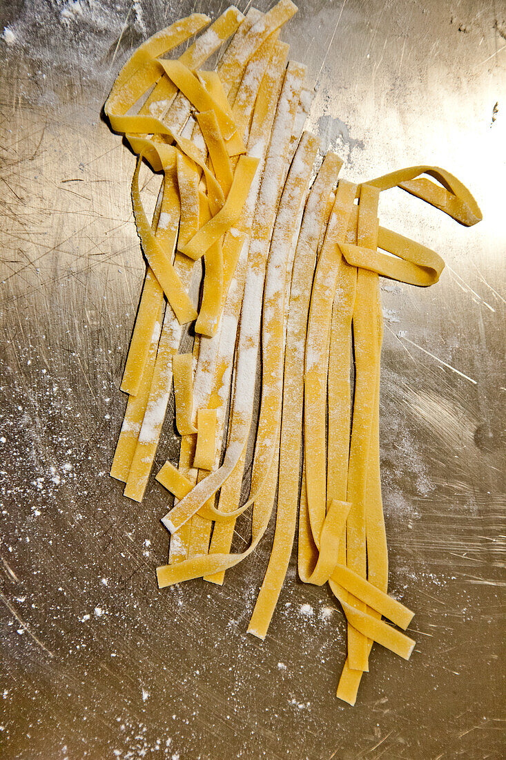 Fresh tagliatelle on a floured work surface