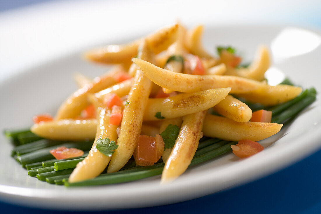 Schupfnudeln with carrots and tomatoes on spring onions