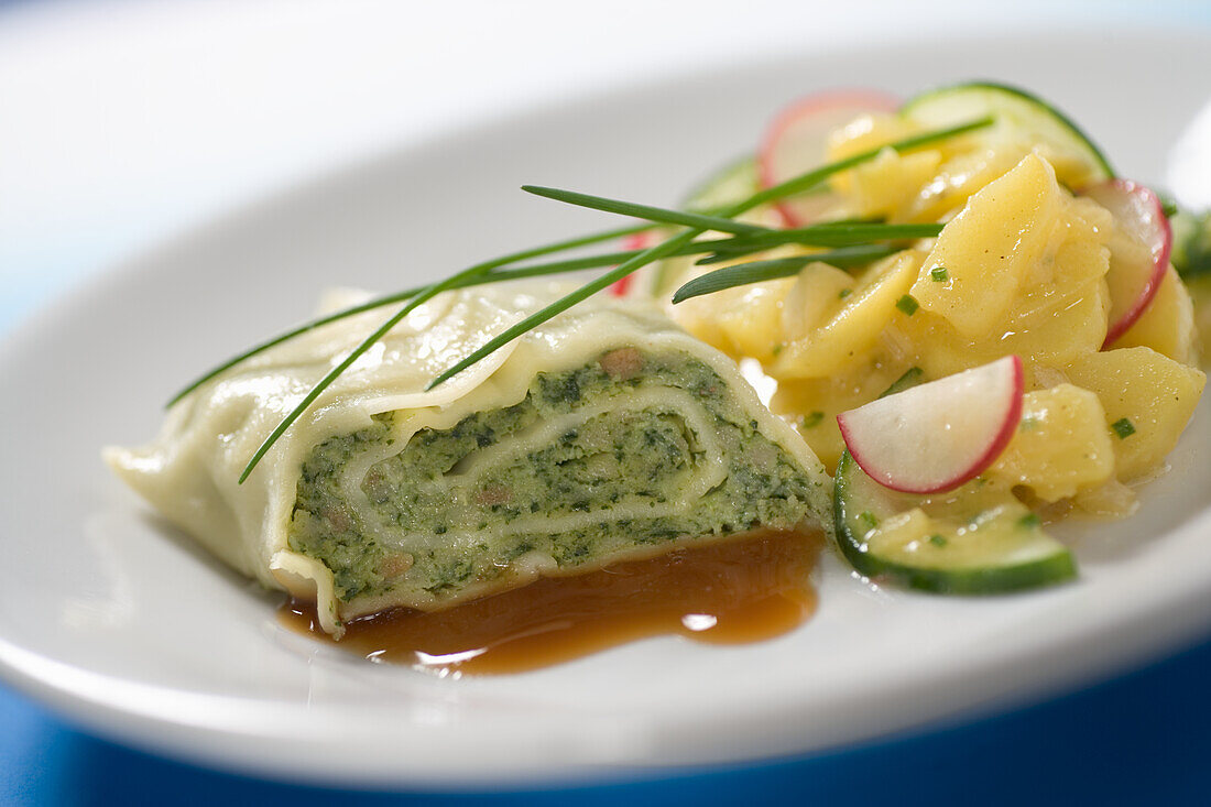 Vegetarian Maultaschen with potato and cucumber salad and radishes