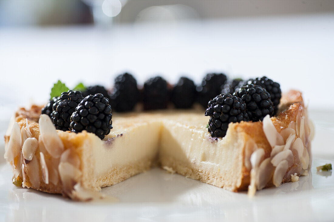 Cream cake with blackberries and almond slivers