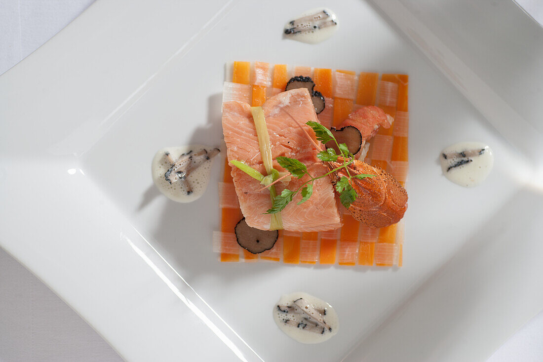 Trout fillet and crayfish tails on a vegetable grid with truffle