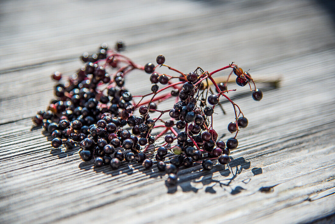 A bunch of elderberries on a wooden table
