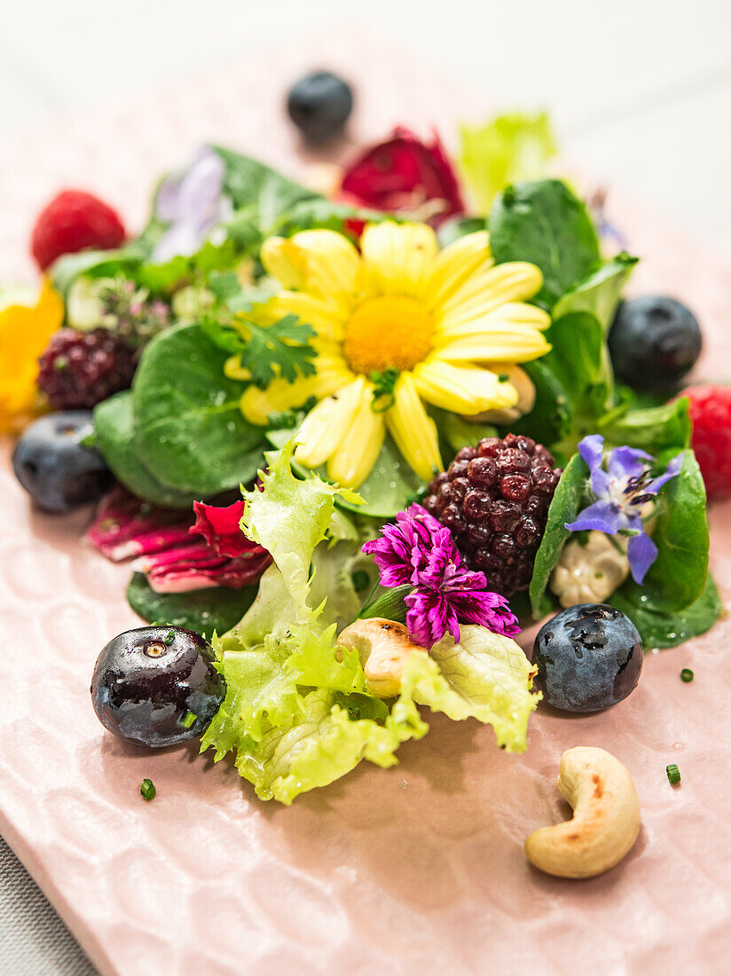 Salat mit Beeren, Cashewnüssen und essbaren Blüten