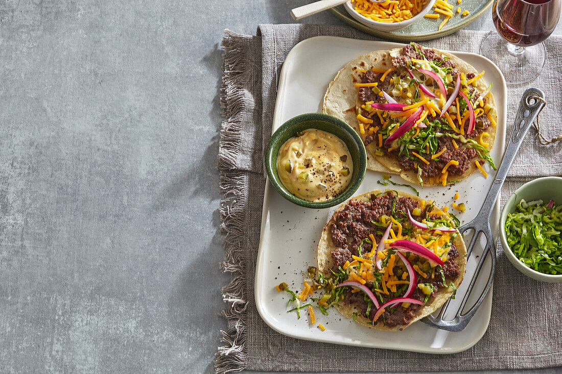 Open beef tacos with cheddar and vegetables