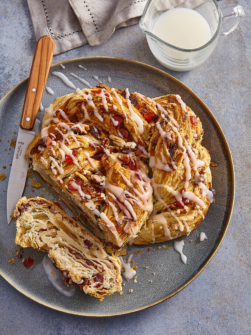 Cinnamon bun with pecan nuts and candied cherries