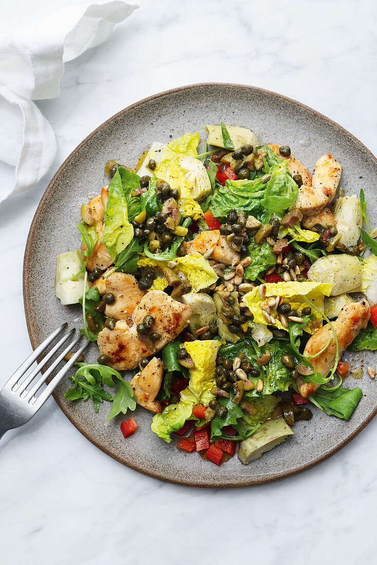 Summer vegetable salad with chicken strips and seeds