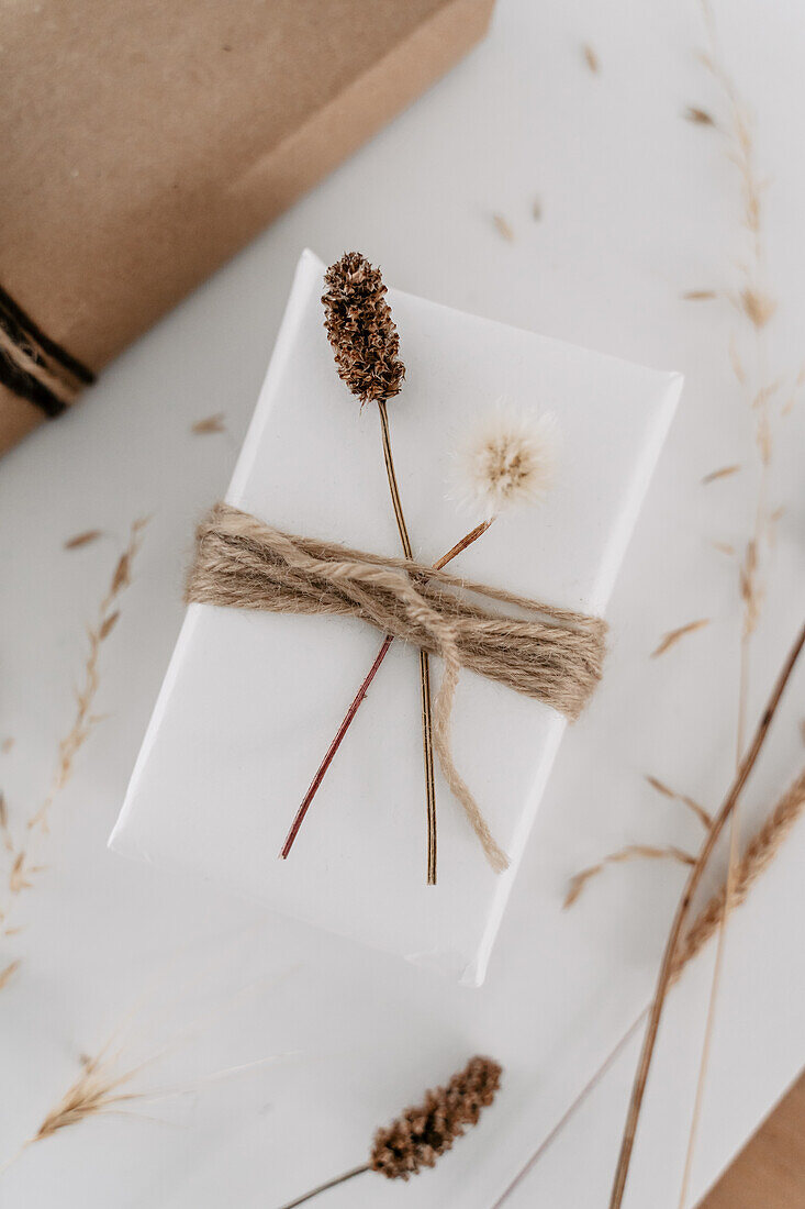 White gift packaging with natural decorations and jute ribbon