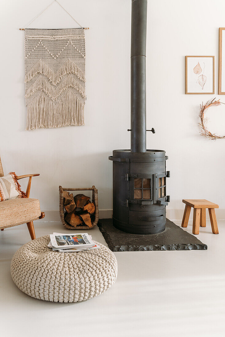 Wood-burning stove next to macramé wall hanging in cosy living room