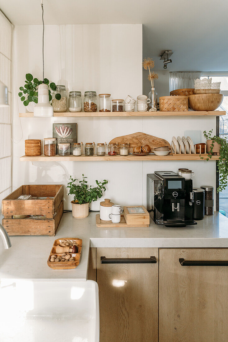 Kitchen unit with coffee machine, wooden shelves and storage jars