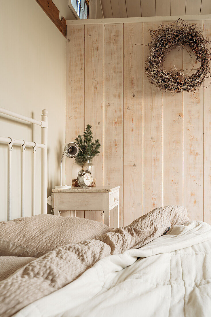 Bedroom with wooden panelling and beige duvet cover