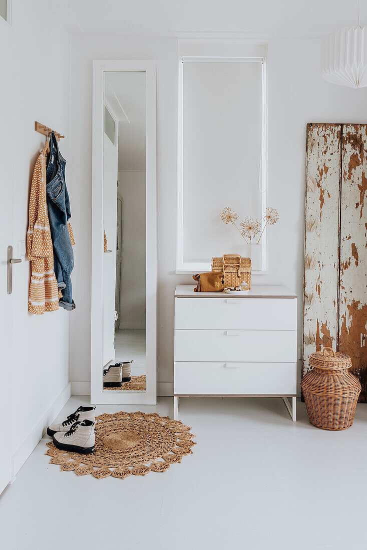 Bright room with white chest of drawers, mirror and rustic decorative elements