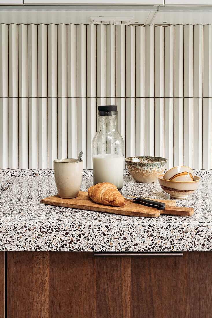 Breakfast in modern kitchen with terrazzo worktop and wooden fronts