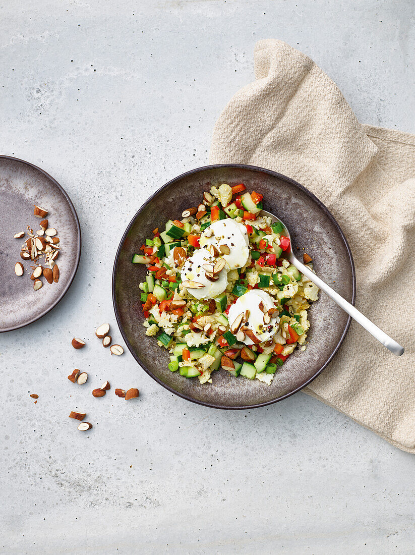 Couscous and vegetable salad with poached eggs and almonds
