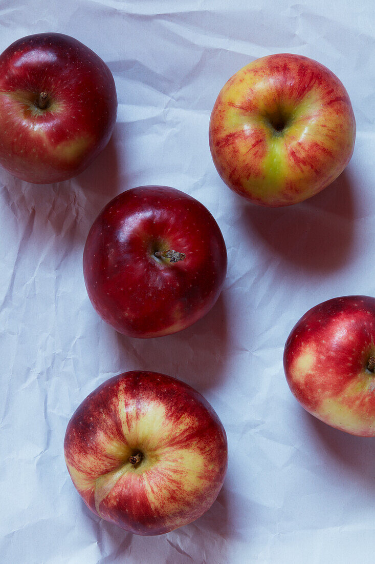 Fünf rote Äpfel auf weißem Untergrund