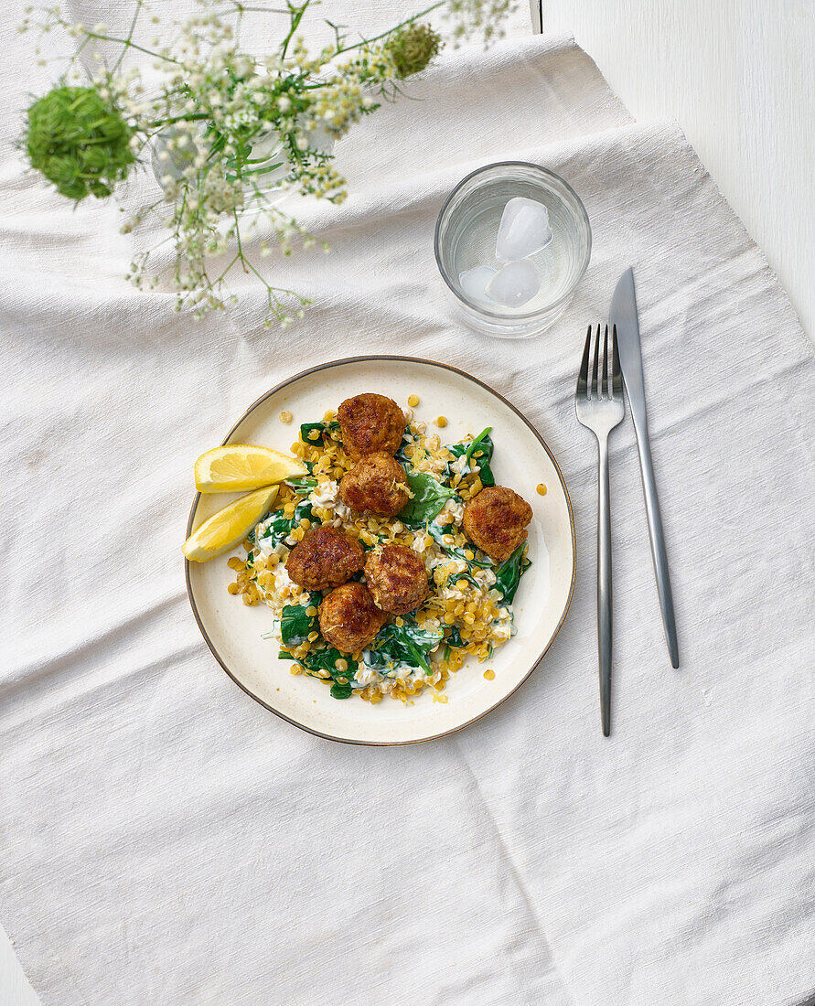 Meatballs on couscous with spinach and lemon