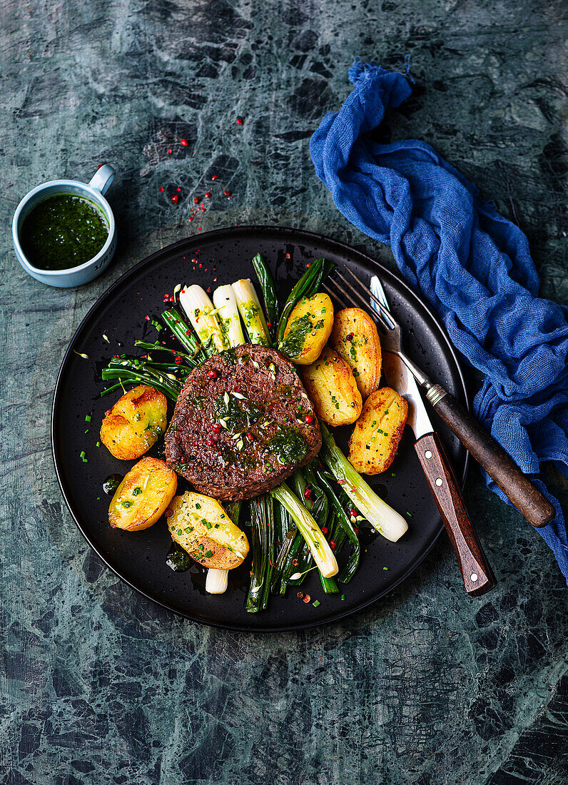 Beef steak with roast potatoes and spring onions