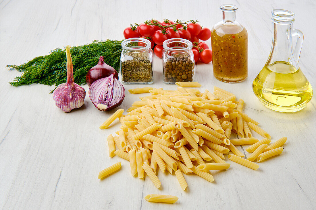 Raw penne pasta with fresh ingredients