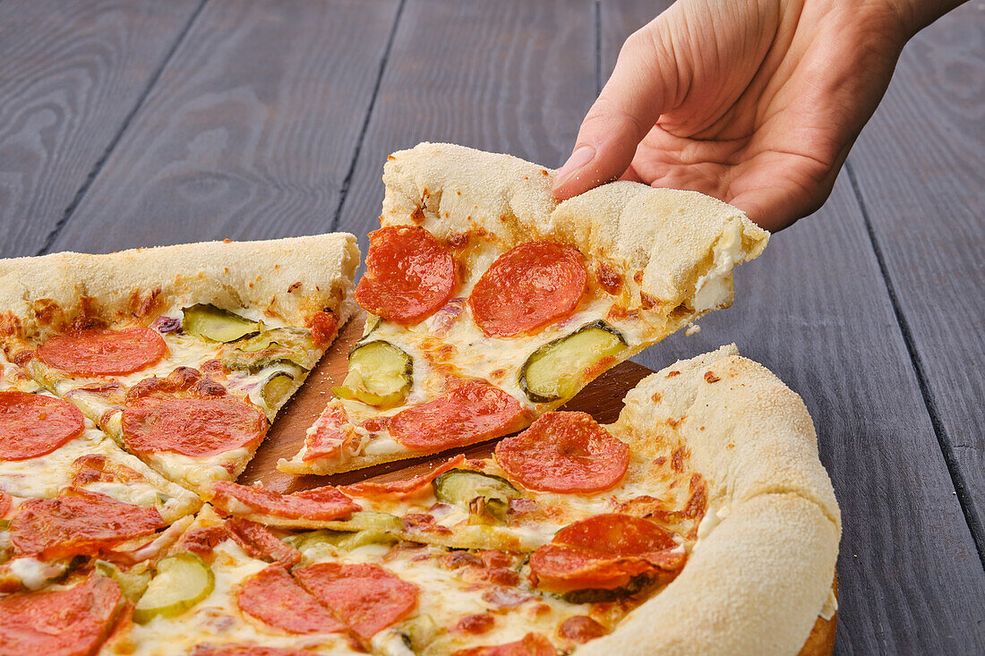 Pizza mit scharfer Salami, Gurke und Käserand