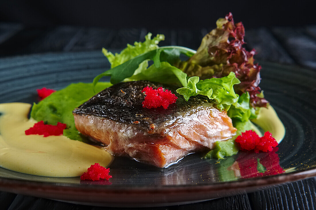 Lachsfilet mit Salat, Kaviar und cremiger Sauce