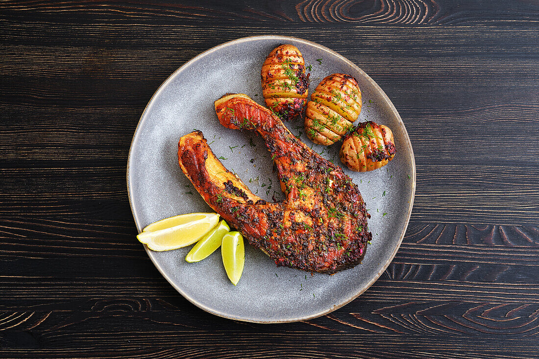 Grilled salmon steak with Hasselback potatoes and lime