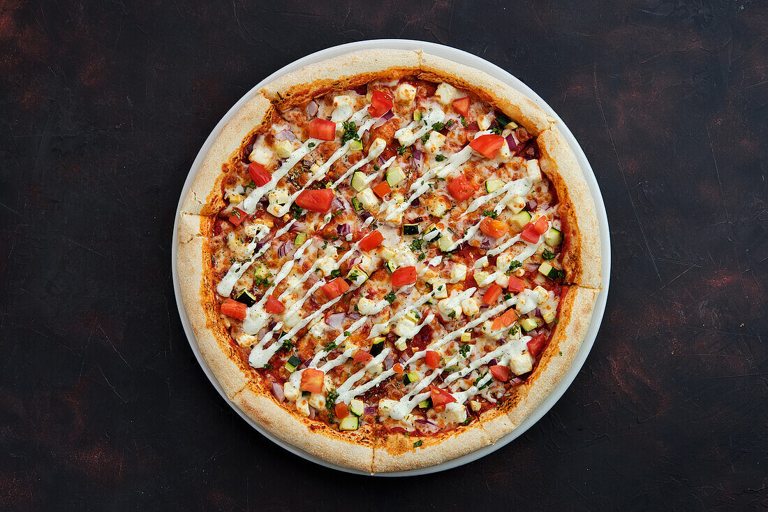 Vegetarian pizza with feta, courgette, tomato and cucumber