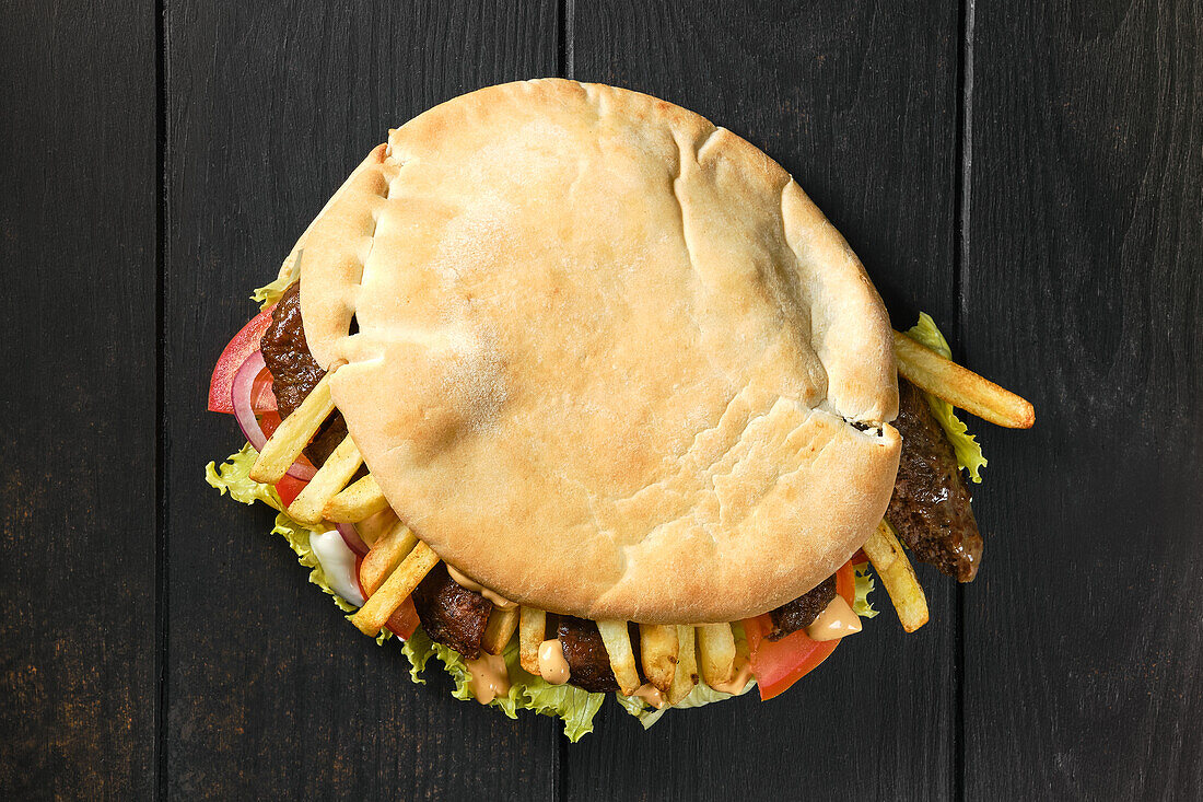 Pita bread with lamb, salad and chips