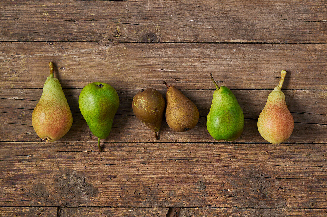 Different types of pears on a wooden surface